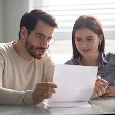 Married couple reading carefully contract terms of conditions.